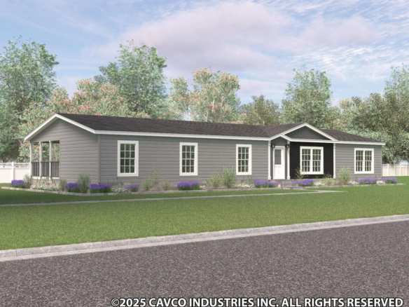Single-story gray manufactured home with white trim, black shingle roof, front porch, multiple windows, and a lawn, surrounded by trees under a partly cloudy sky.