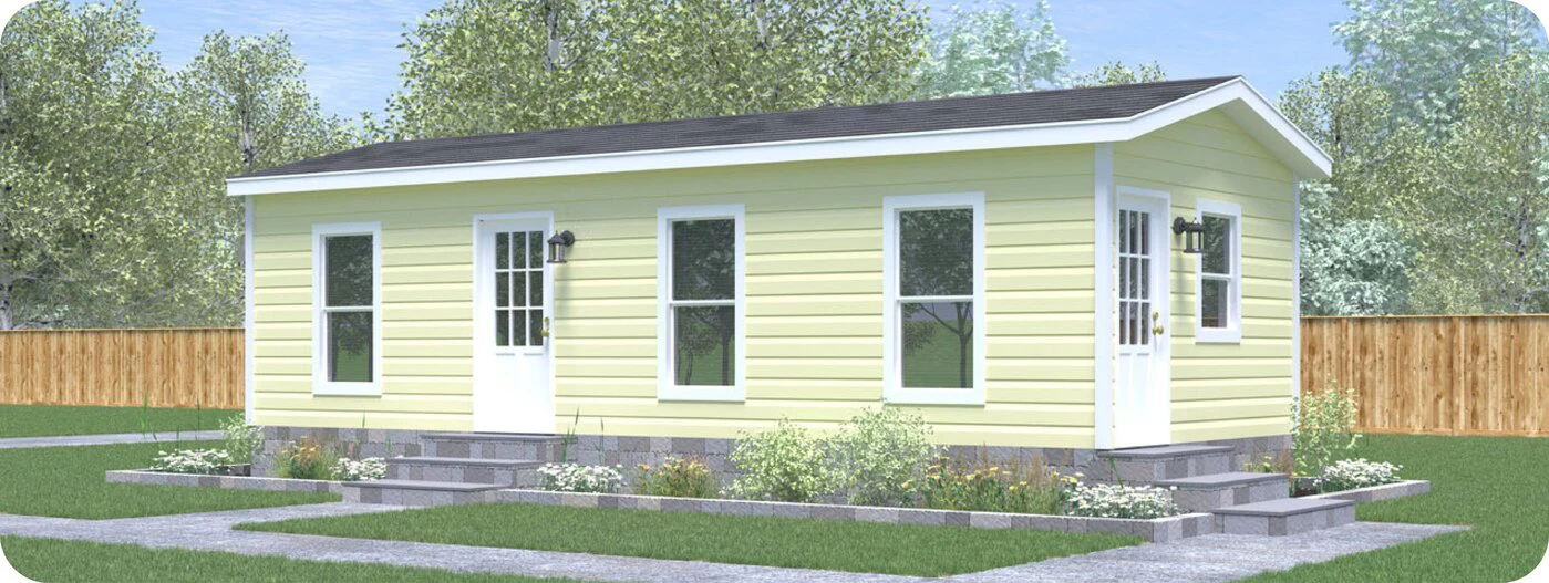 A small, single-story yellow house with white trim, two entry doors, and multiple windows, situated in a fenced yard with green grass and shrubs.