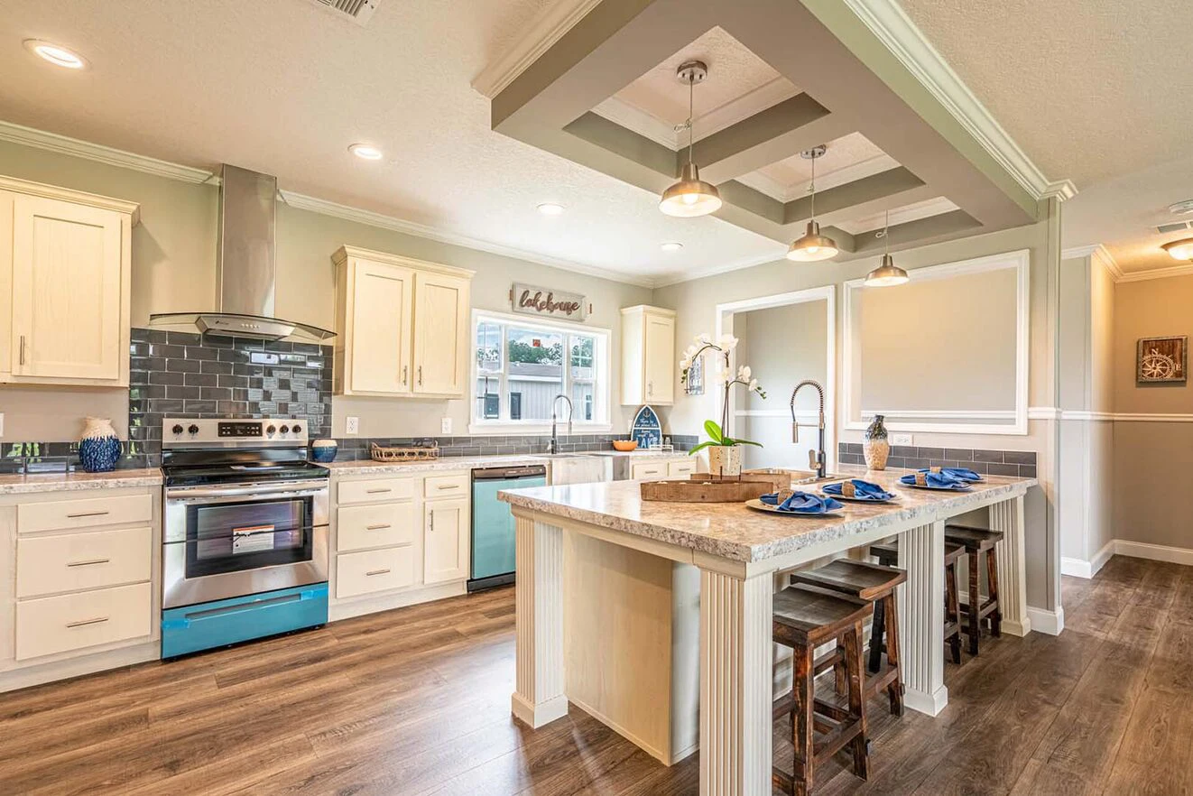 Modern kitchen with white cabinets, stainless steel appliances, a center island with stools, pendant lighting, and wooden flooring.