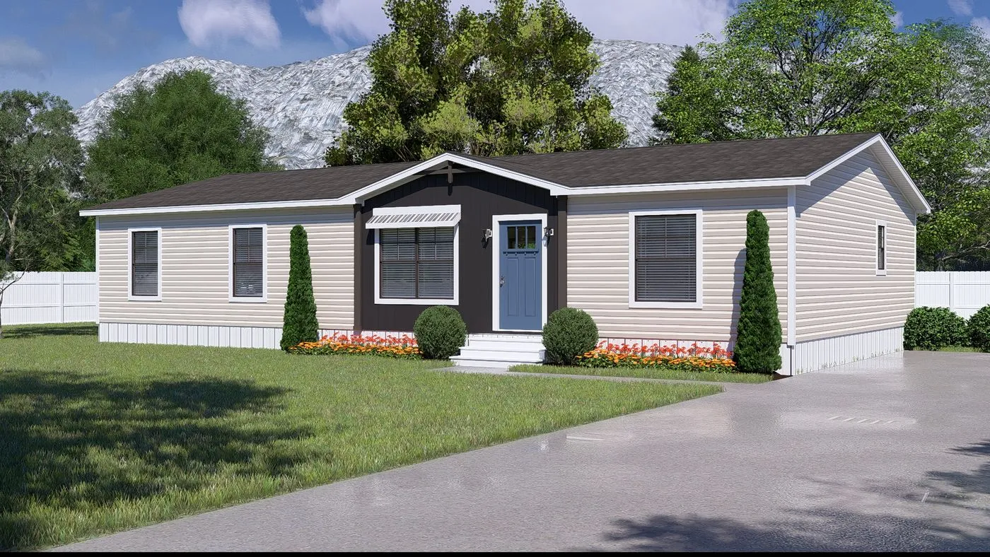 A single-story beige manufactured home with a blue front door, white trim, and simple landscaping, set against trees and a mountain backdrop.