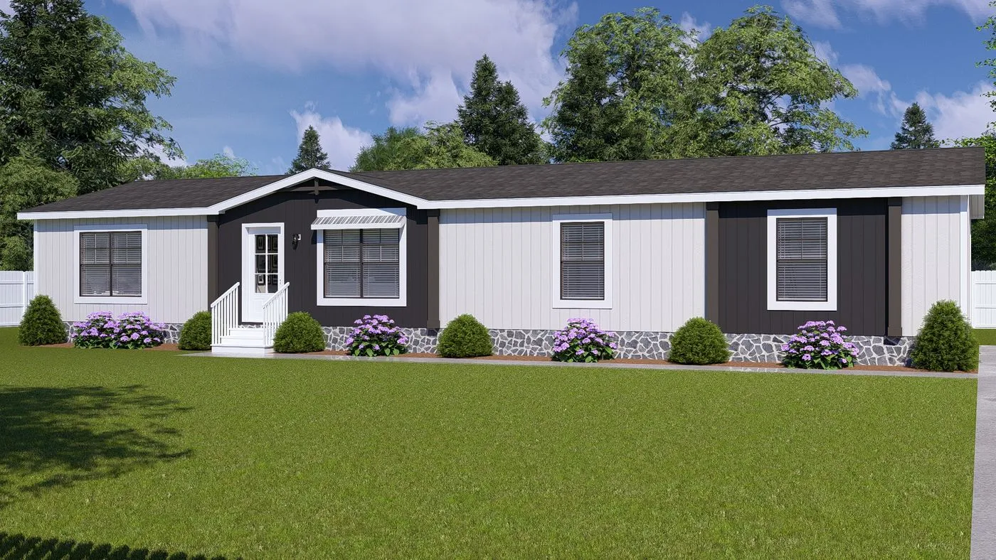 A single-story manufactured home with white and dark trim, front steps, shrubs, purple flowers, and a large green lawn. Trees and a white fence are in the background.