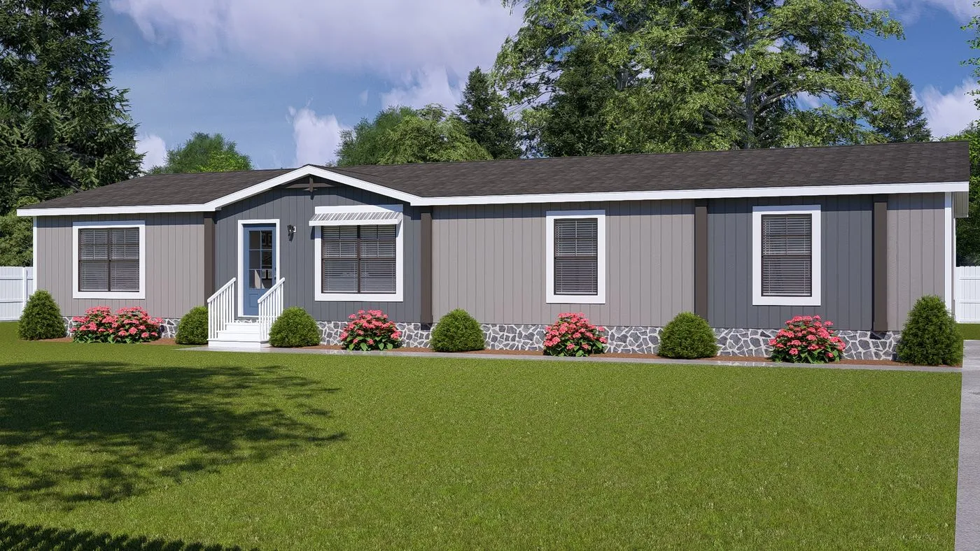 A single-story manufactured home with gray siding, white trim, a small front porch, and a well-kept lawn with bushes and pink flowers in front.