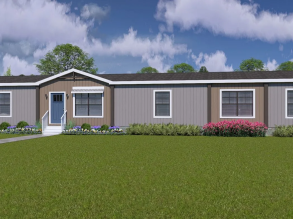 A single-story manufactured home with gray siding, a blue front door, several large windows, and landscaping in the front yard under a partly cloudy sky.