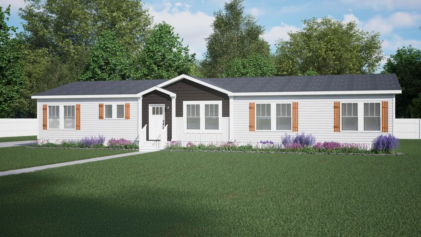A single-story, white manufactured home with brown shutters, a small front porch, and landscaped garden beds on a lawn with trees in the background.
