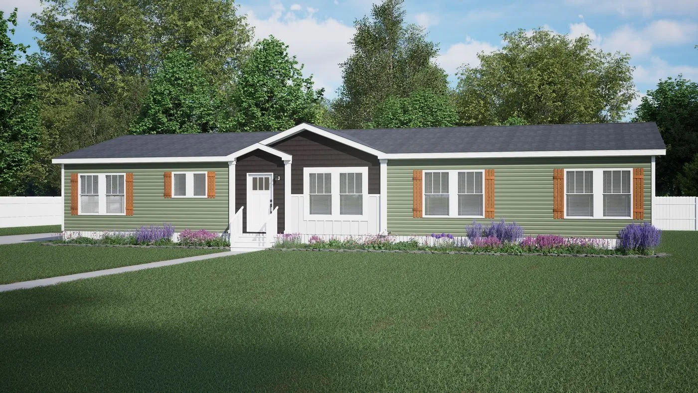 A single-story, green manufactured home with white trim, brown shutters, front steps, and landscaped garden beds, set on a grassy lawn with trees and a white fence in the background.